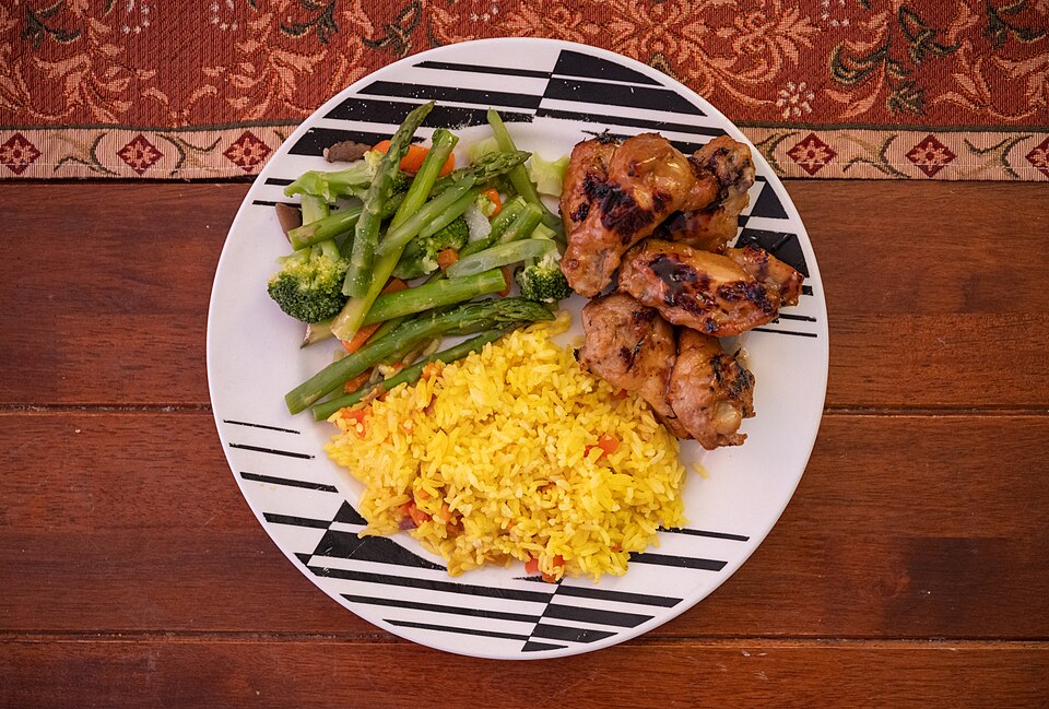 Chicken, yellow rice and mixed vegetables on a dinner plate